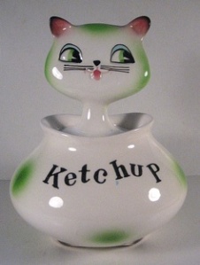 This is, far as I can tell, a ceramic ketchup bottle with a ceramic kitten head peeking out.